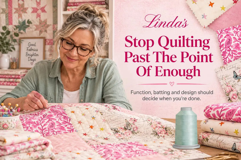 Quilter in a sage-green shirt sewing a pink, cream and floral patchwork quilt at a table in a bright studio — deciding when the quilting is finished