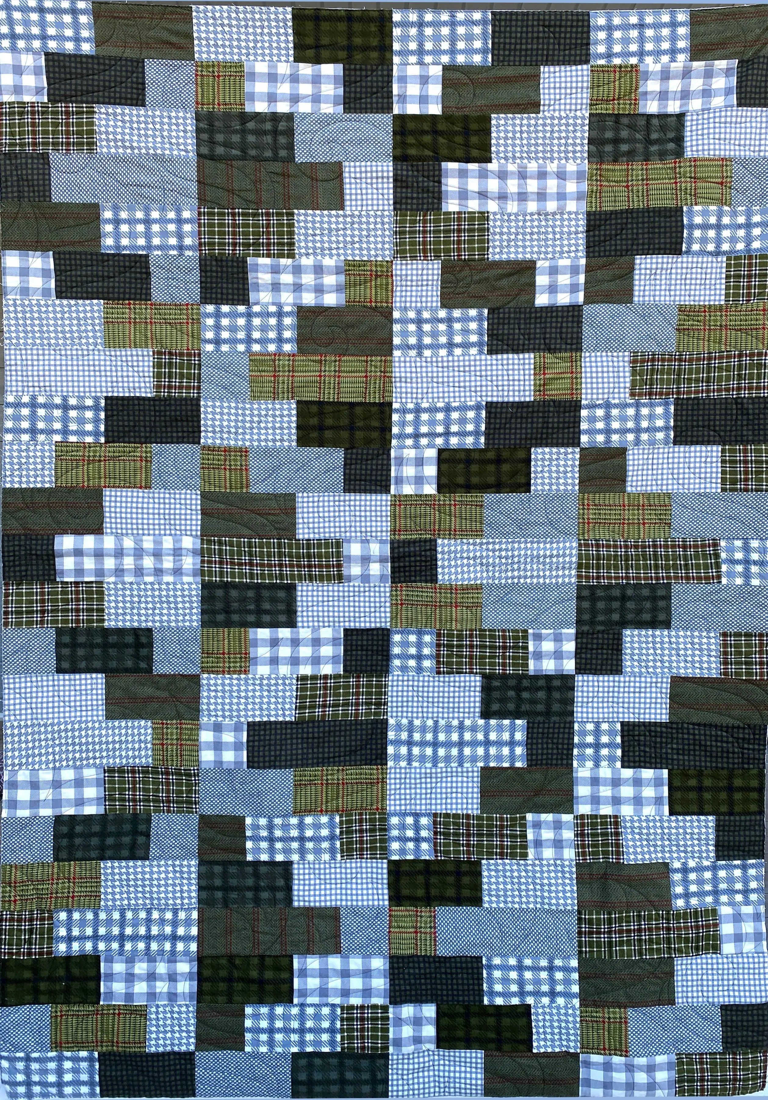 Patchwork quilt with a pattern of blue, green, and black squares.